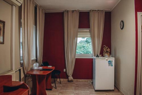 cocina con nevera, mesa y ventana en Duet Plus Motel, en Voytovtsy
