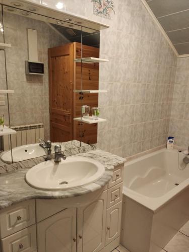 une salle de bain avec un lavabo, une baignoire et un miroir dans l'établissement Maison proche plage avec terrasse ensoleillée, à Dunkerque