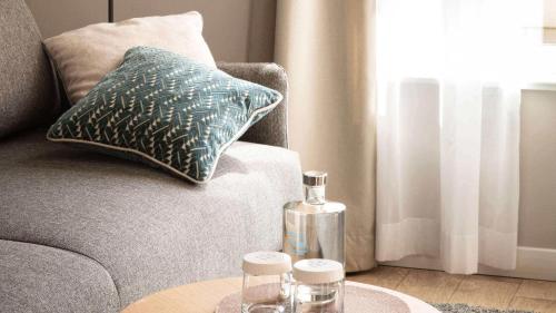 a glass bottle on a table next to a couch at City Hotel Merano in Merano