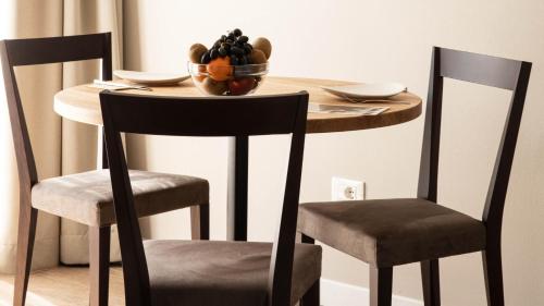 a wooden table with two chairs and a bowl of fruit at City Hotel Merano in Merano