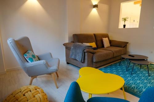 a living room with a couch and a yellow table at Silken Casa Platerias Siglo XV in Zaragoza