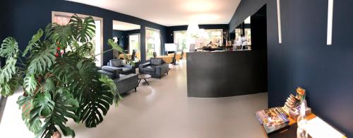 a lobby with a waiting room with chairs and plants at Villa Regina in Riva del Garda