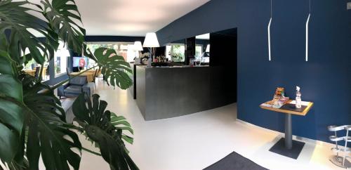 a restaurant with a blue accent wall and a plant at Villa Regina in Riva del Garda
