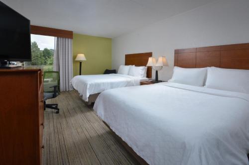 a hotel room with two beds and a flat screen tv at Holiday Inn Express Lynchburg by IHG in Lynchburg