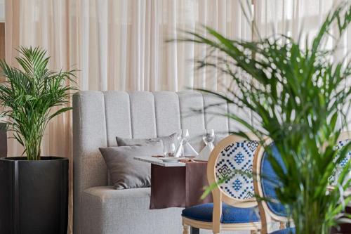 a living room with a couch with a table and plants at Terceira Mar Hotel in Angra do Heroísmo