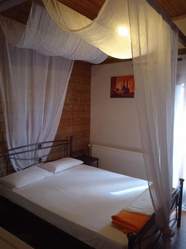 a bedroom with a bed with a canopy at Theasis suites-Ορεινή Φιλοξενία in Kato Trikala Korinthias