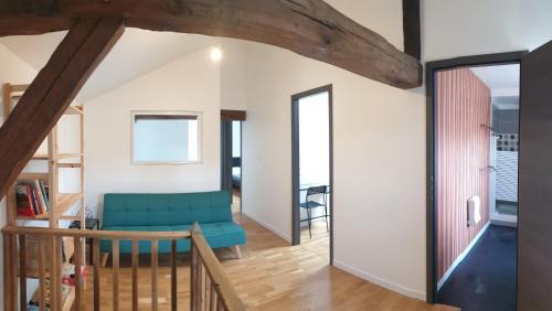 - un salon avec un canapé bleu et un escalier dans l'établissement Gîte au Village du Domaine Le Colombier, à Dienville