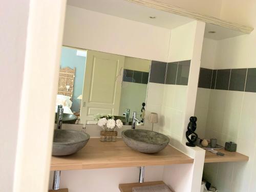 - une salle de bains avec deux lavabos en face d'un miroir dans l'établissement la maison du bonheur, à Saint-Pierre