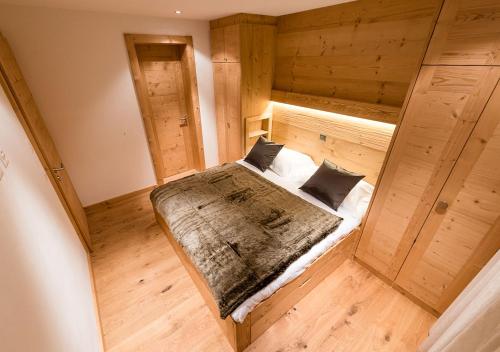 a large wooden bed in a room with wooden floors at Nendaz 4 Vallées & SPA 4* Superior in Nendaz
