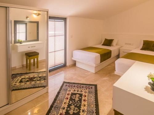 Pokój hotelowy z 2 łóżkami i lustrem w obiekcie Stonehouse Aparts Dublex 3+1 mit Meerblick und Jakuzzi Kalkan No:5 w mieście Kalkan