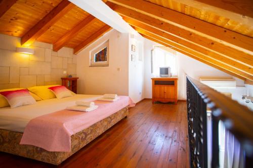 ein Schlafzimmer mit einem Bett in einem Zimmer mit Holzböden in der Unterkunft Apartmani Slobodan in Makarska