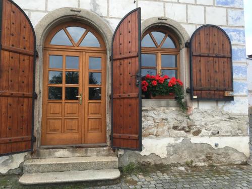 un edificio con puertas de madera y flores en una ventana en Apartmán Horní Brána, en Telč