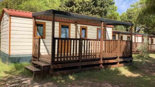 a large wooden cabin with a large deck at Camping La Scogliera in Santa Cesarea Terme