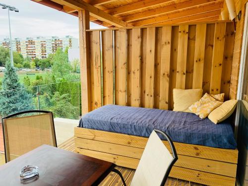1 cama en una cabaña de madera con mesa y sillas en Egria Apartments, en Eger