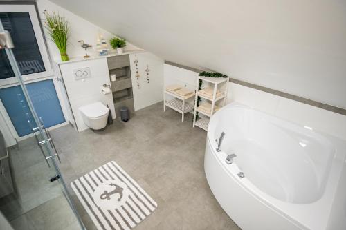 a bathroom with a white tub and a sink at Mein Beach House in Löbnitz
