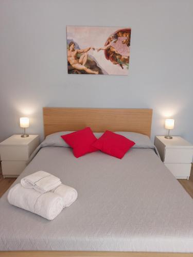 a bed with two towels and red pillows on it at Sapore di Mare Holidays in Maiori