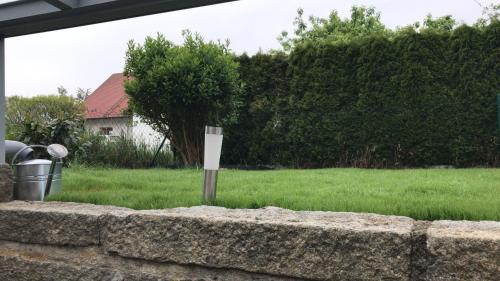 a sign in a yard next to a stone wall at Ferienwohnung im Herzen der Holledau in Pörnbach