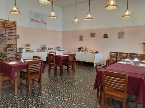 a restaurant with purple tables and chairs and a counter at Wonna Bay Vila Lodge-Catembe in Maputo