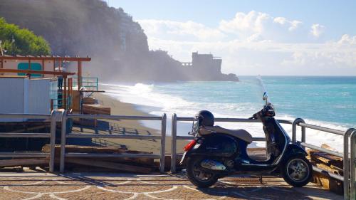 a scooter parked on the beach near the ocean at Sapore di Mare Holidays in Maiori