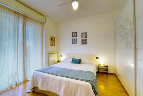a white bedroom with a bed and a window at CaseOspitali - Casa Certosa, bilocale a pochi minuti da Rho Fiera in Milan