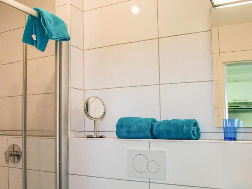 a shower with blue towels on a shelf in a bathroom at Obst- und Ferienhof Schäfler in Hattnau