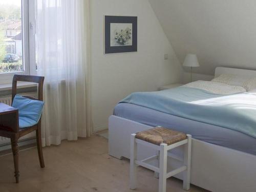 een slaapkamer met een bed, een stoel en een raam bij Ferienhaus und Gästezimmer Cleo in Uhldingen-Mühlhofen
