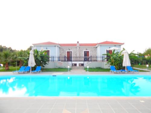 a swimming pool in front of a house at Kalloni village apartments in Skala Kallonis