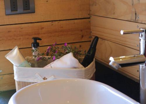 a bathroom sink with a bottle of champagne and flowers at Casa Mirador Roca in Matanzas