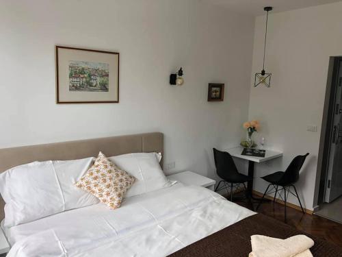 a bedroom with a white bed and a table and chairs at Labroski Apartments in Ohrid