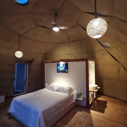 AlıncaにあるTürkdomes Glampingのベッドルーム1室(大型ベッド1台、照明2つ付)