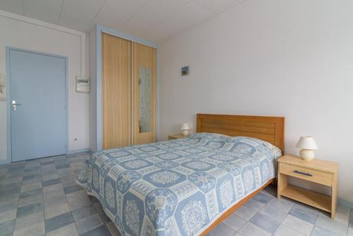 une chambre avec un lit et une table de chevet en bois dans l'établissement île d’Oléron, 1082, à Rochefort