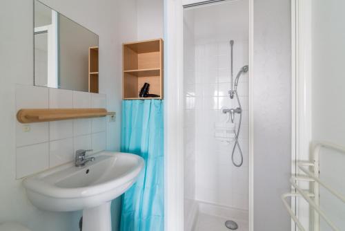 une salle de bain blanche avec un lavabo et une douche dans l'établissement île d’Oléron, 1082, à Rochefort