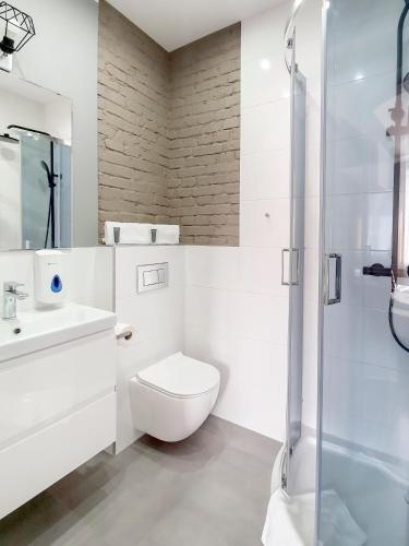 a bathroom with a toilet and a sink and a shower at Kamienica Morska Gdynia in Gdynia