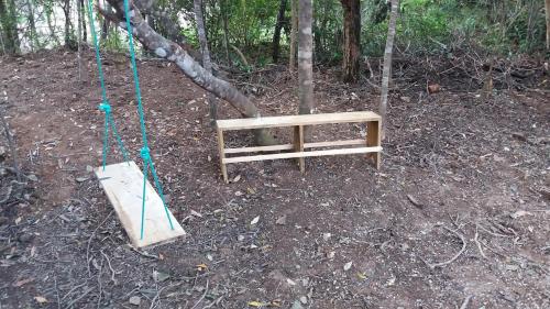 a wooden swing in the woods with a swing at Beco das Garrafas in Vale do Capao
