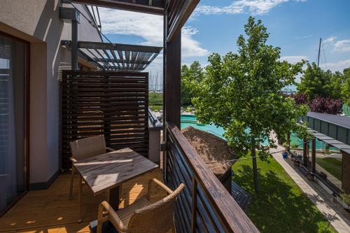 a balcony of a house with a table and chairs at Hotel Golden Lake Resort in Balatonfüred