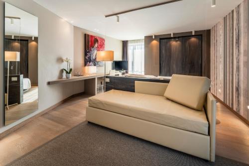 a living room with a couch and a kitchen at Suites Hotel Astor in Belluno