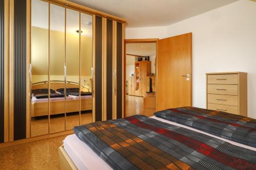 ノイキルヒにあるFerienwohnung Merkのベッドルーム1室(ベッド1台、ドレッサー付)