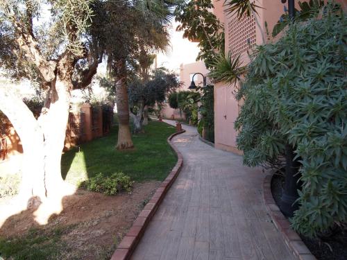 a walkway in a yard with trees and a building at Apartamentos Mar Azul in Almerimar