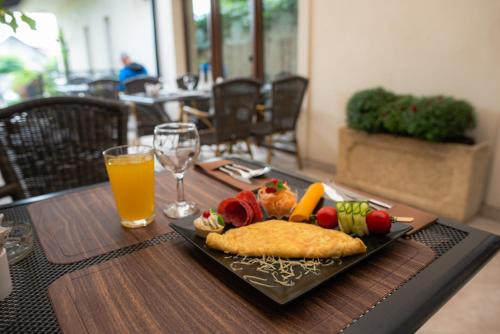 a plate of food on a table with a glass of orange juice at Curtea Bizantina in Suceava