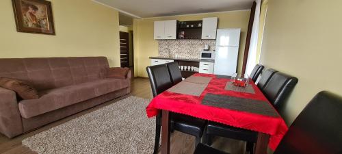 salon ze stołem i kanapą oraz kuchnia w obiekcie Sauliaus apartamentai VIP w Poniewieżu