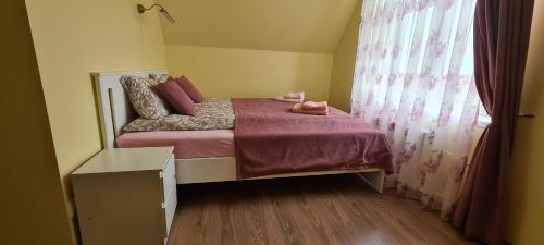 a small bedroom with a bed and a window at Sauliaus apartamentai VIP in Panevėžys