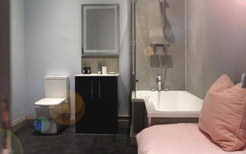 a bathroom with a toilet and a sink and a bath tub at The Globe Angle in Pembrokeshire