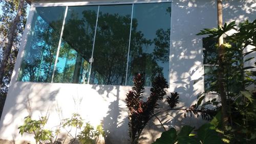 a glass house in the middle of a garden at Morada dos Elfos in Vale do Capao