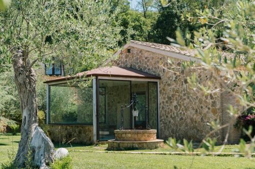 a small stone house with a glass door at Leano Agriresort in Piazza Armerina
