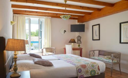 En eller flere senge i et værelse på Hotel Au Marais