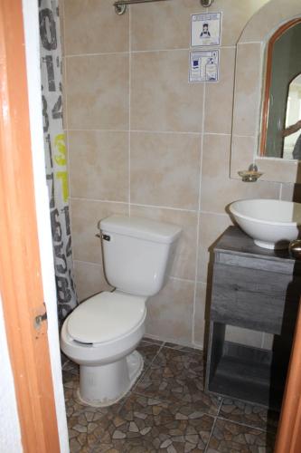 a bathroom with a toilet and a sink at D'Cesar Hotel Acapulco in Acapulco