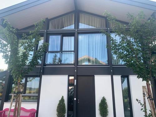 a house with large glass windows and plants at Residence in Chieming
