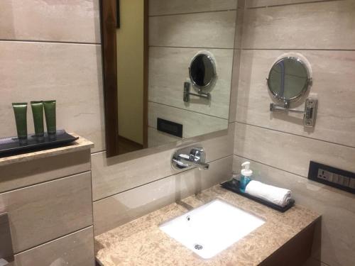 a bathroom with a sink and a mirror at Midtown Grand in Hisār