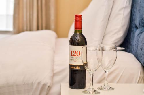 a bottle of wine sitting on top of a bed at Hotel St George by Nina in Dublin