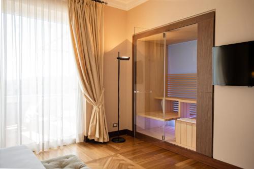 a bedroom with a glass closet with a glass door at Villa Maria Hotel & SPA in Francavilla al Mare